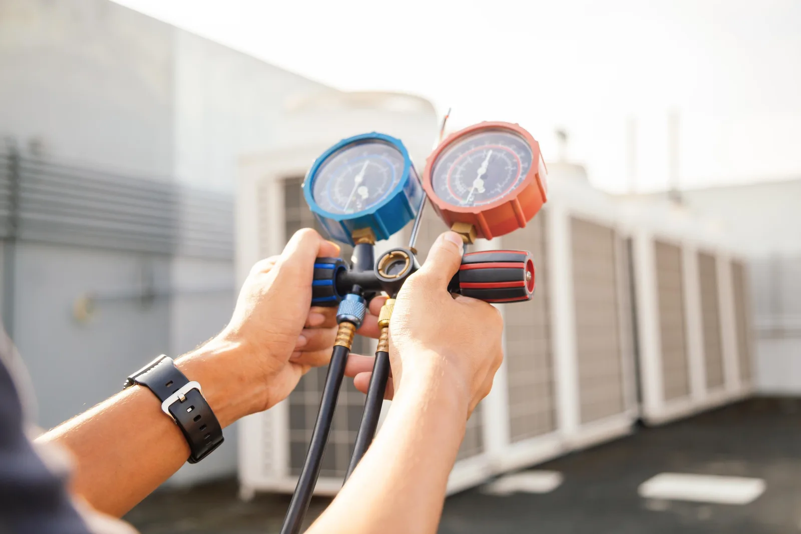 ac-repair-cost-phoenix-technician-diagnosis An HVAC technician in Phoenix using a gauge set to diagnose a residential air conditioning system before quoting the repair cost.