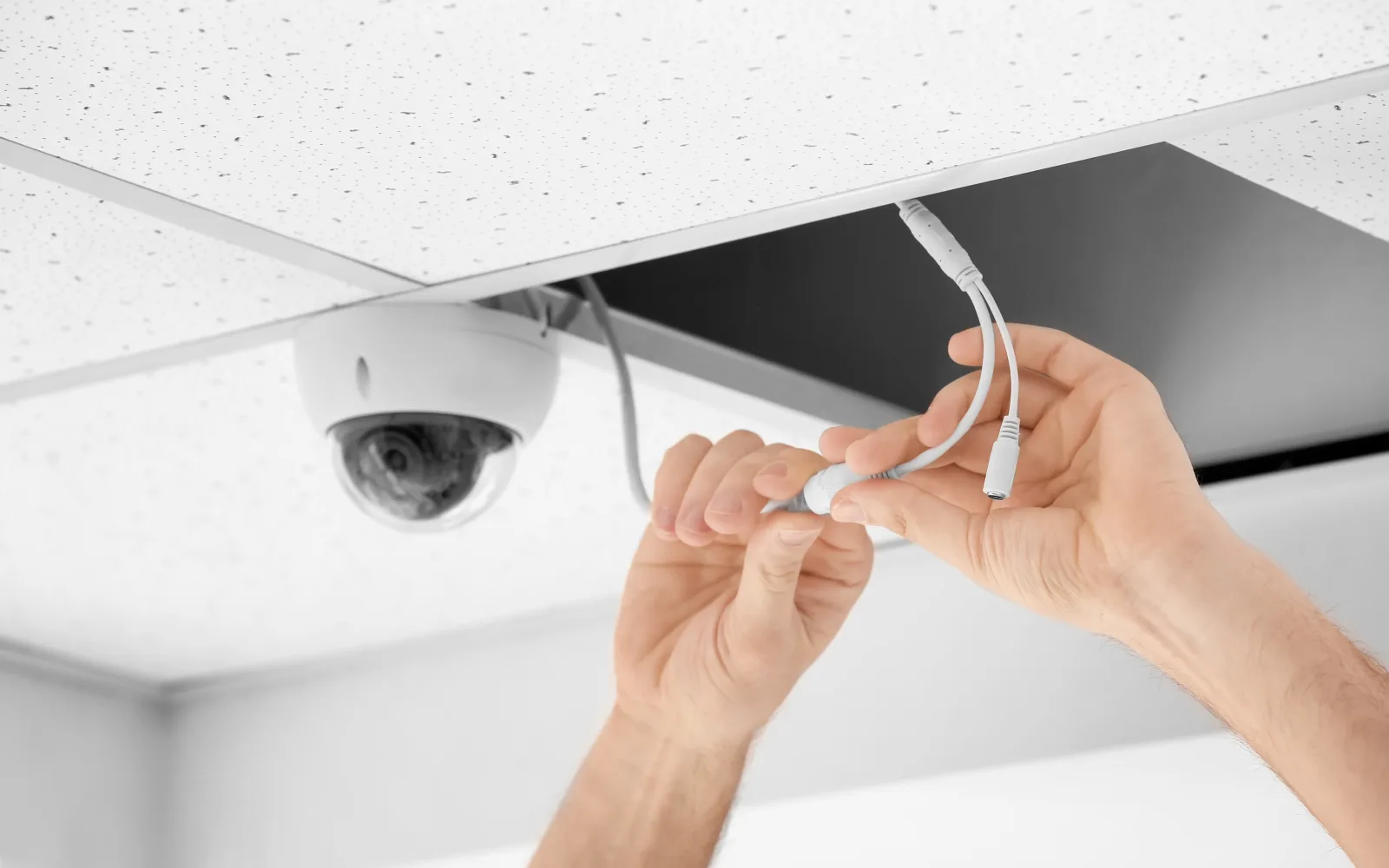 Access control in Phoenix, Arizona — a technician installing a ceiling-mounted surveillance camera that pairs with the building's entry system.