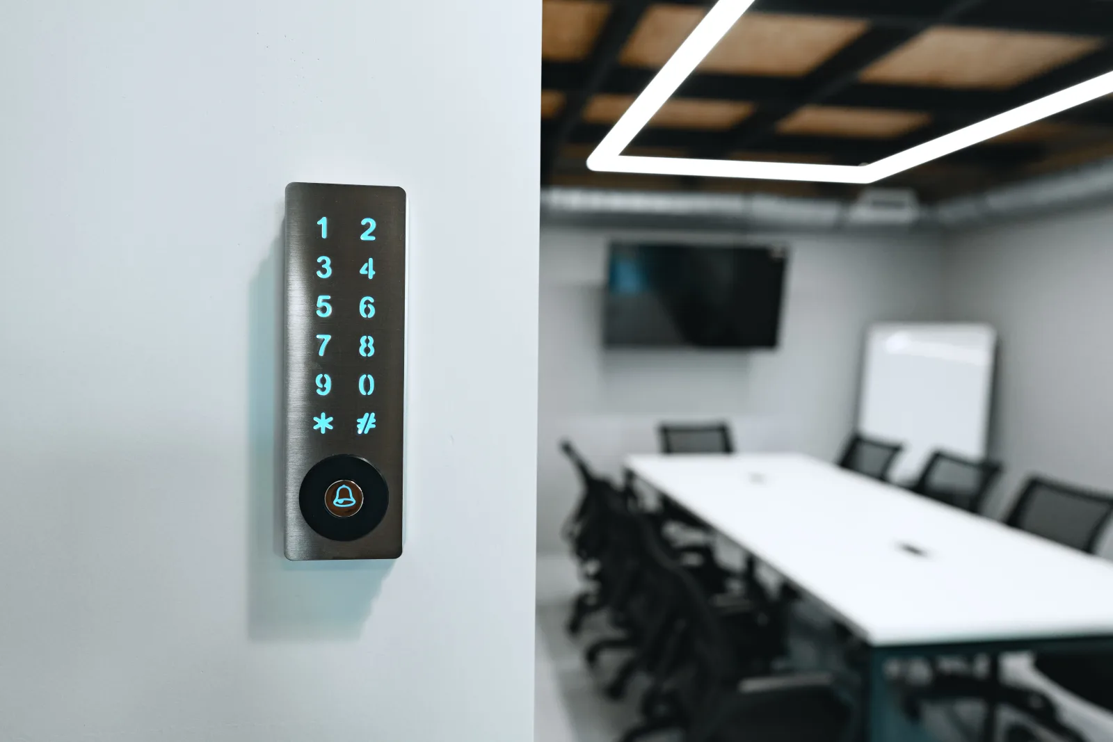 Access control in Phoenix, Arizona — a keypad entry panel mounted beside an office suite door with a conference room visible behind it.