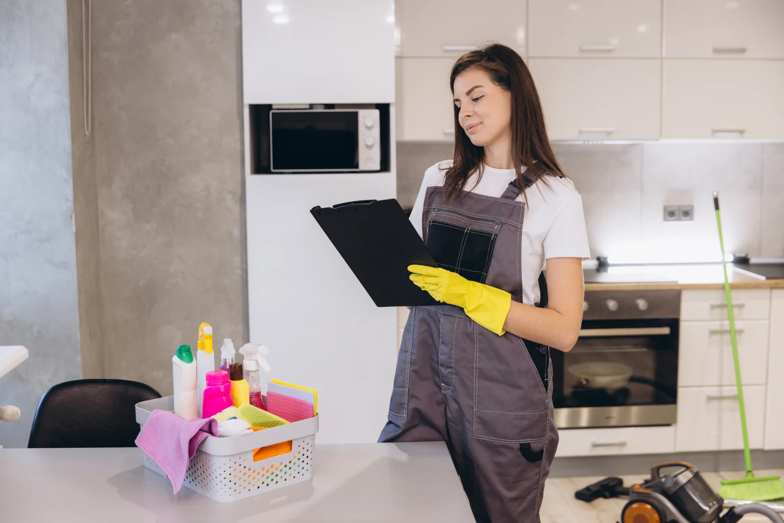 A turnover cleaner reviewing a checklist in a modern Phoenix kitchen during an Airbnb inspection walk-through.