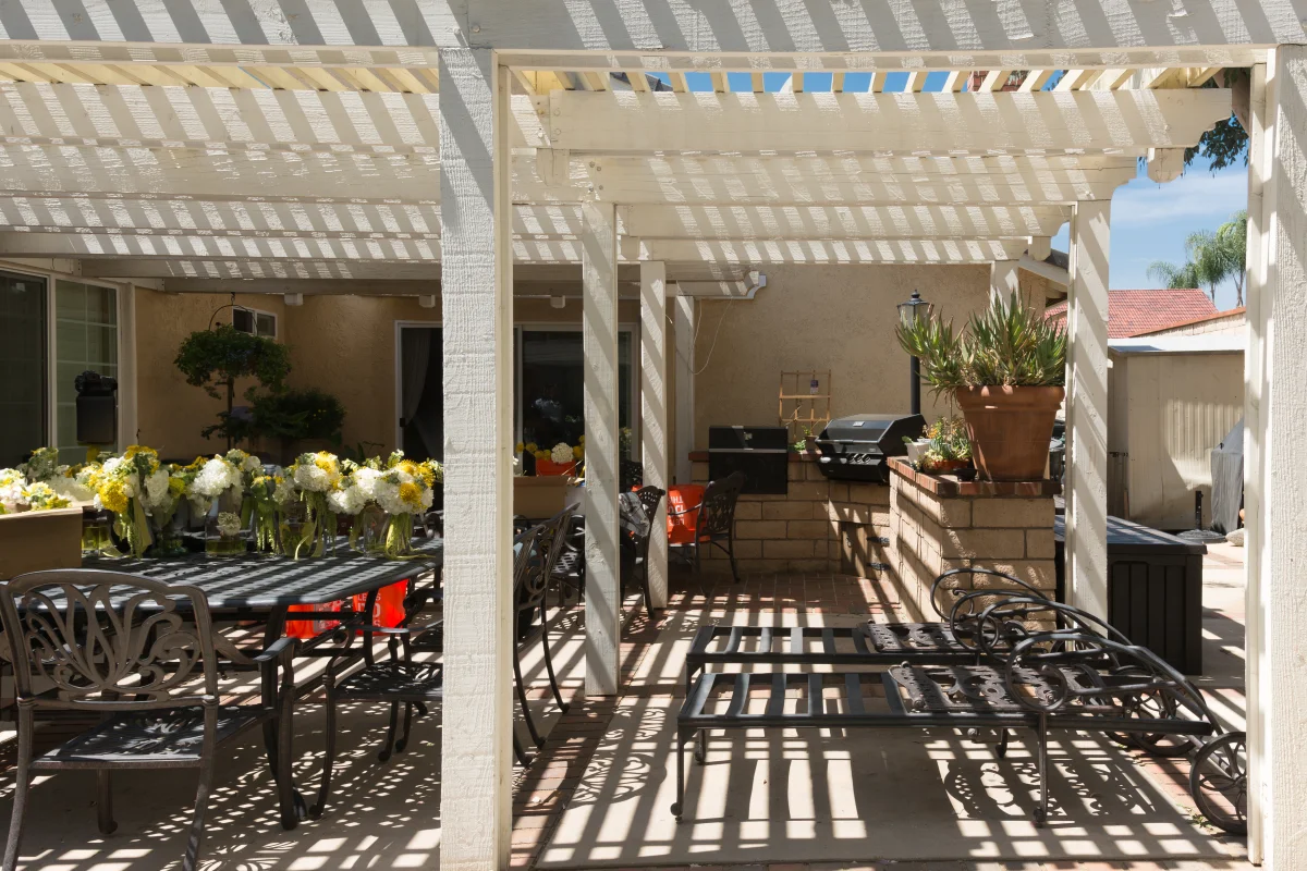 alumawood-pergola-phoenix-aluminum-lattice-patio-cover An Alumawood-style aluminum lattice pergola over a Phoenix, Arizona backyard patio with dining and lounge seating.