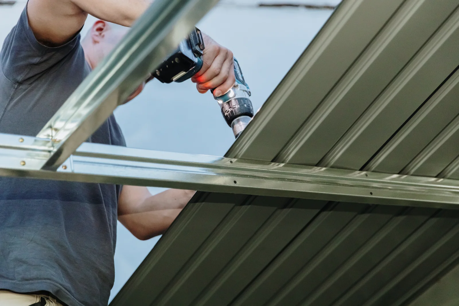 alumawood-pergola-phoenix-aluminum-panel-installation A close-up of aluminum roof panels being fastened together during an Alumawood-style patio cover installation.