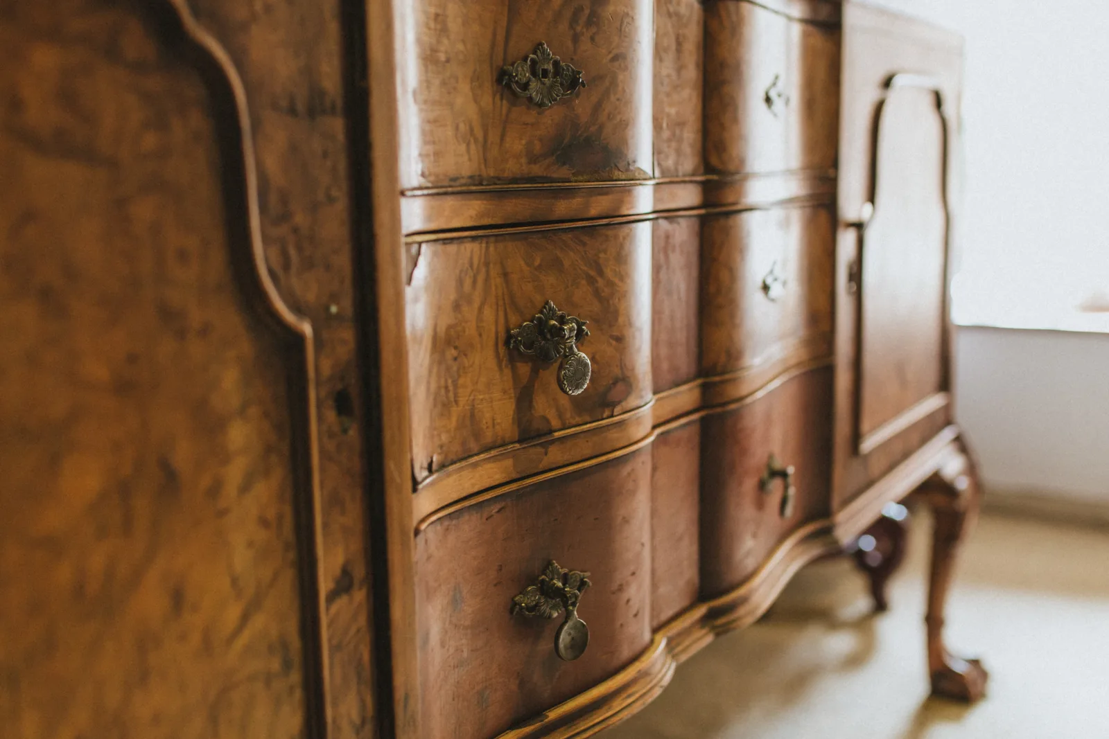 antique-furniture-repair-phoenix-heirloom-dresser-detail Antique furniture repair in Phoenix, Arizona — close-up of an ornate antique wood dresser with original brass hardware.