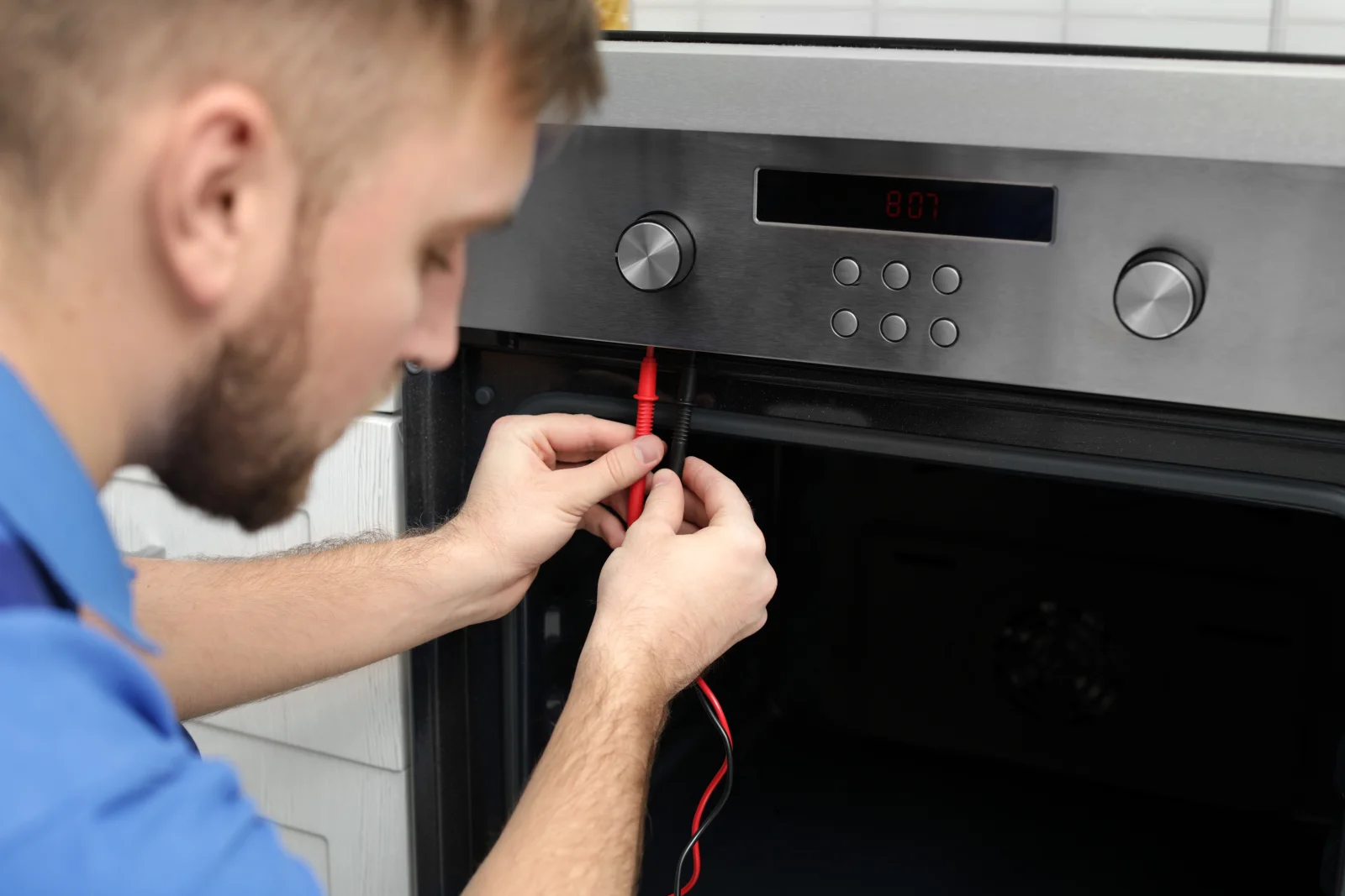 appliance-repair-north-phoenix-oven-diagnostic Appliance repair in North Phoenix — a technician using a multimeter to test an oven's electronic control panel.