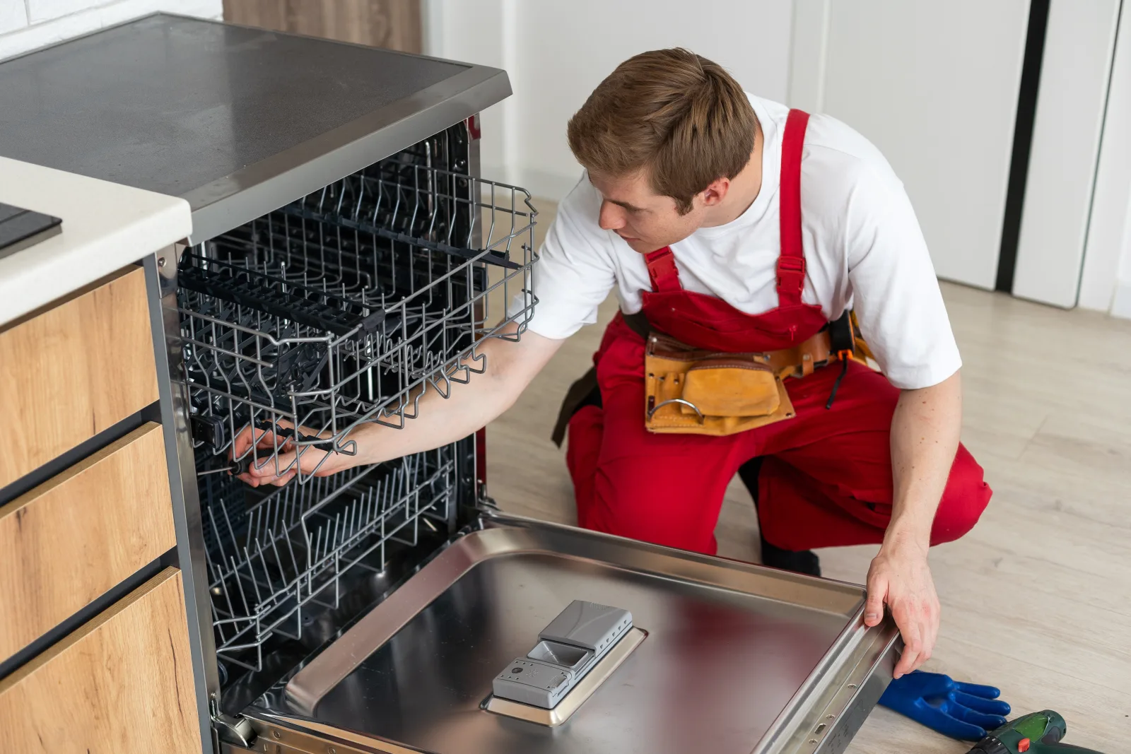 asko-dishwasher-repair-phoenix-technician-diagnosing-rack-mechanism A Phoenix appliance technician diagnosing the rack mechanism and control panel on an Asko dishwasher.