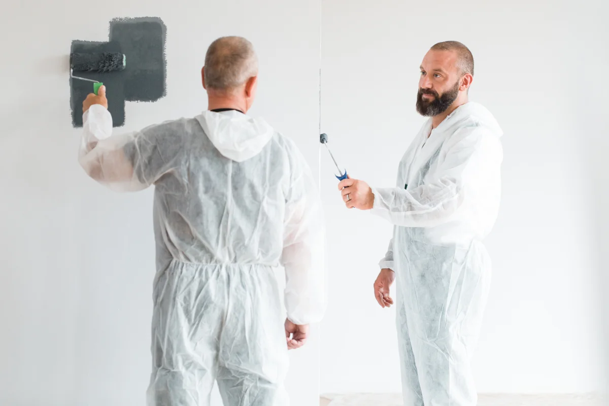 bathroom-painting-phoenix-in-progress Bathroom painting in Phoenix, Arizona — professional painters in protective coveralls applying a fresh coat of paint to interior walls.
