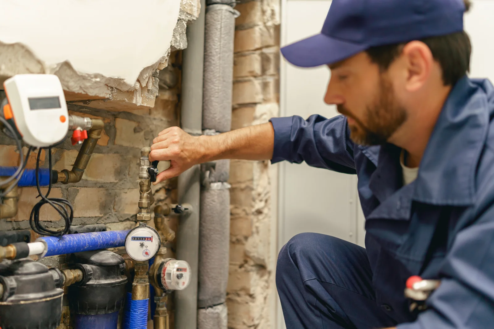 burst-pipe-repair-phoenix-valve-shutoff-diagnosis A Phoenix plumber shutting off a valve at the water meter and checking exposed pipes to diagnose a hidden leak, the careful shutoff and inspection a burst pipe or slab leak repair starts with.