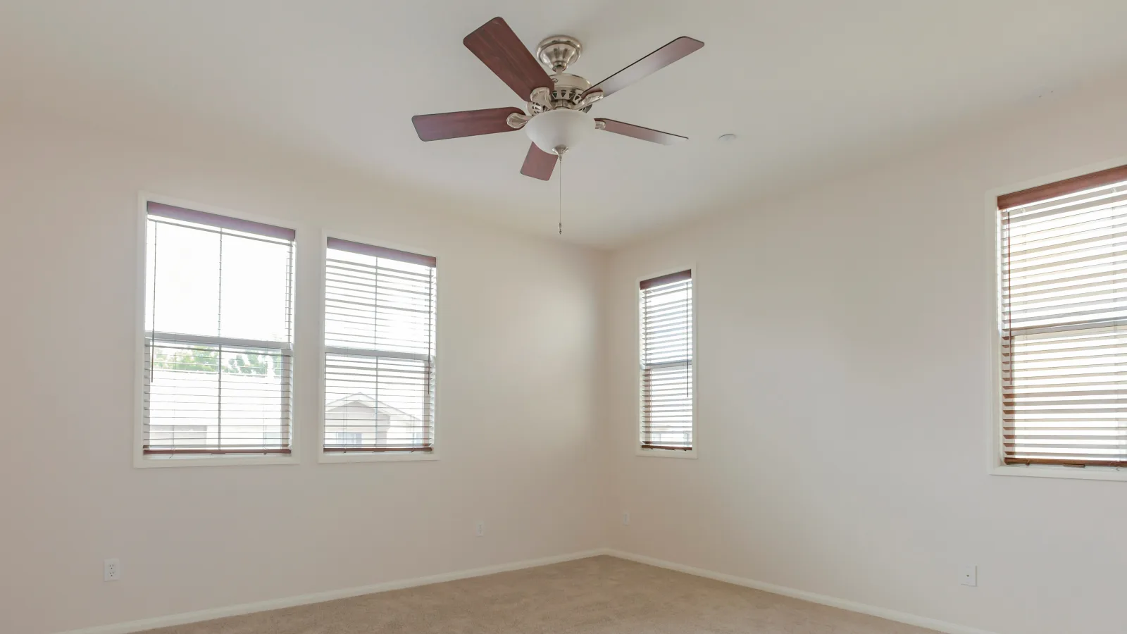 Ceiling fan repair in Phoenix, Arizona — a freshly repaired ceiling fan with a light kit installed in a bright bedroom.