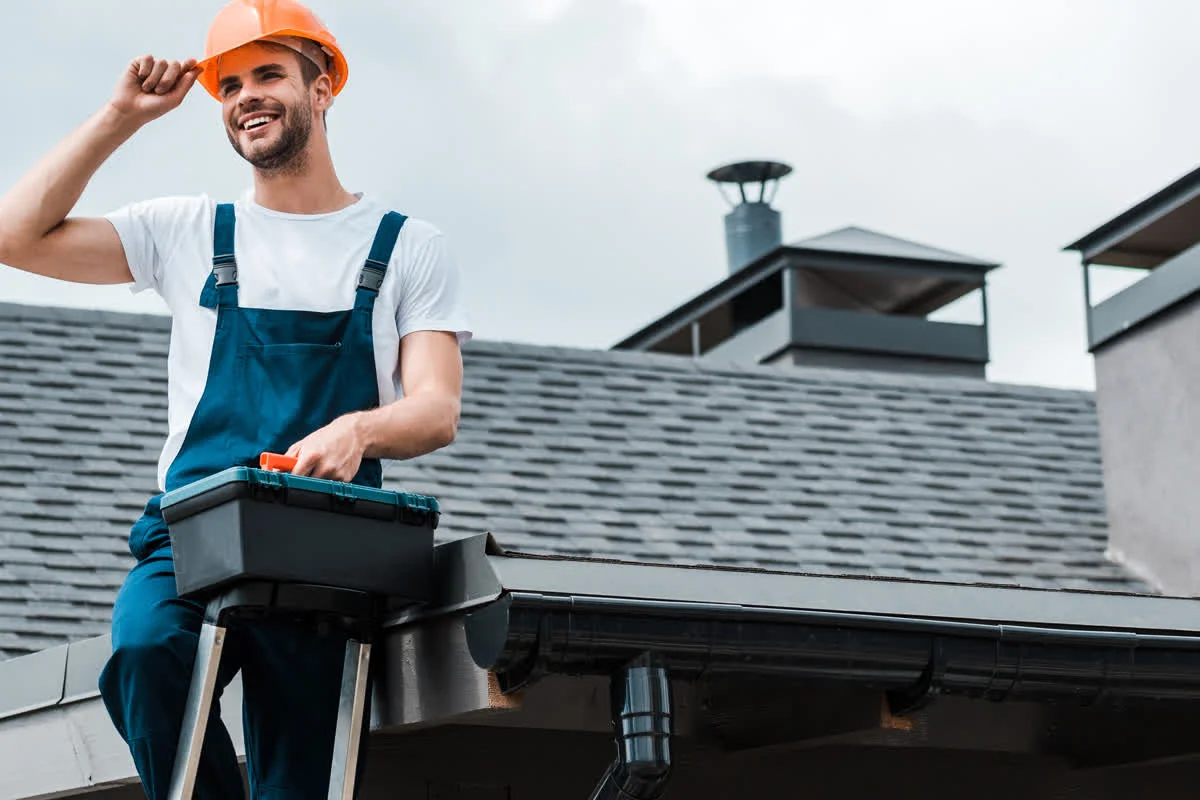 chimney-cleaning-phoenix-az-technician-rooftop Chimney cleaning in Phoenix, Arizona — a licensed chimney technician in a hard hat on a rooftop, ready to sweep and inspect the flue.