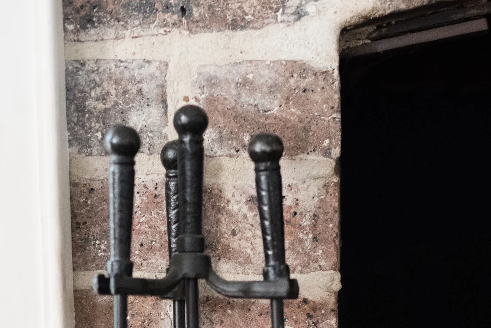 chimney-cleaning-phoenix-az-sweep-tools Chimney sweep tools staged beside a brick fireplace opening ahead of a Phoenix chimney cleaning appointment.