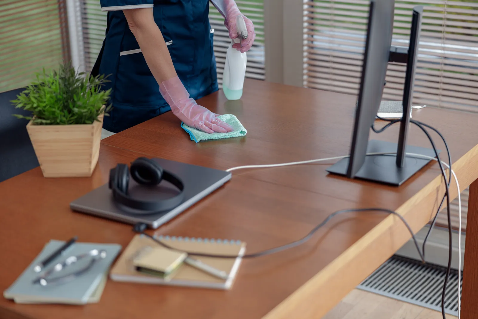 commercial-cleaning-phoenix-az-office-clean A commercial cleaner wiping down desks and surfaces in a bright Phoenix office workspace during a nightly janitorial visit.