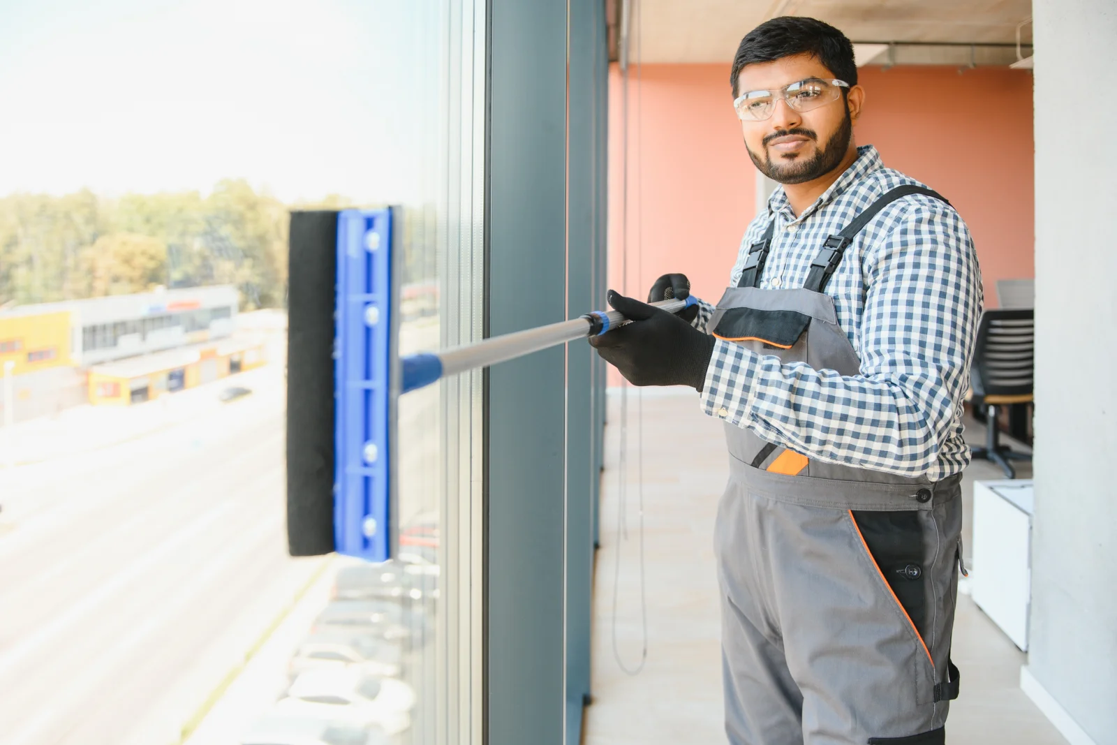 A commercial window cleaner working on the glass storefront of a Phoenix business as part of a standalone cleaning service.