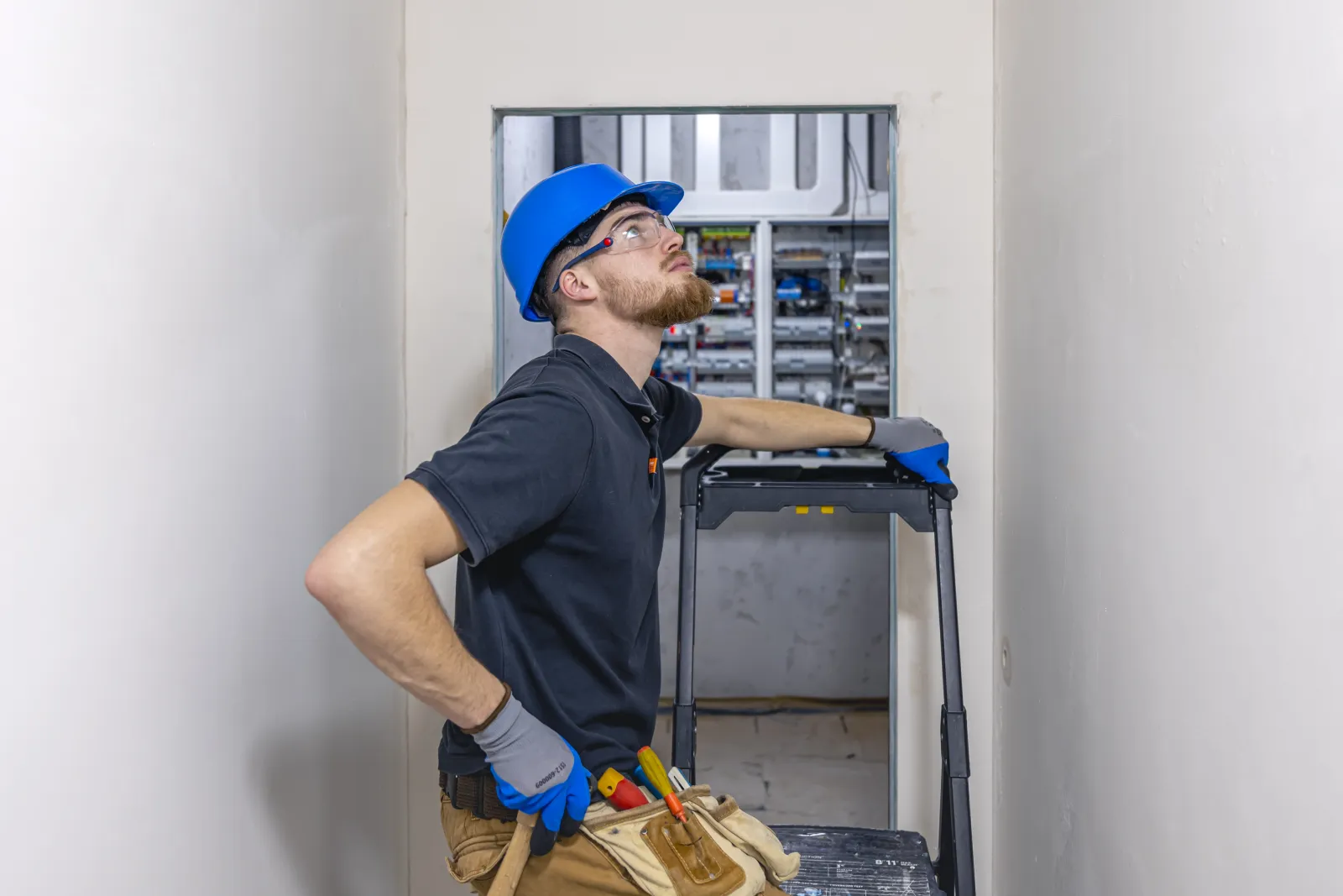 commercial-electrical-contractors-phoenix-az-panel A commercial electrician working inside a large electrical panel at a Phoenix business, the kind of commercial electrical work ShowUp Promise connects property owners with.