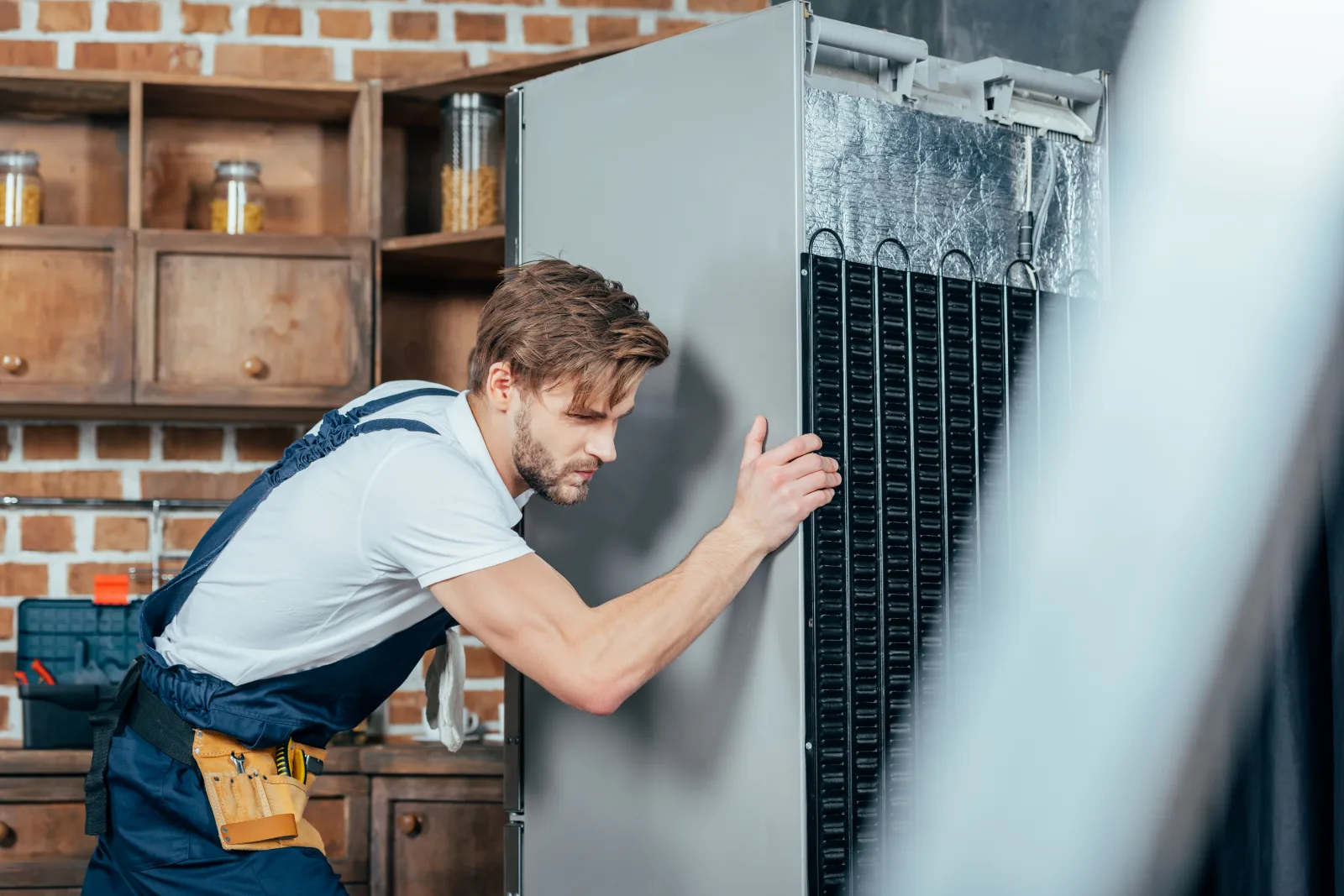 commercial-refrigeration-repair-phoenix-coil-inspection A technician inspecting the evaporator coil inside a commercial reach-in refrigeration unit to diagnose why it will not hold temperature.