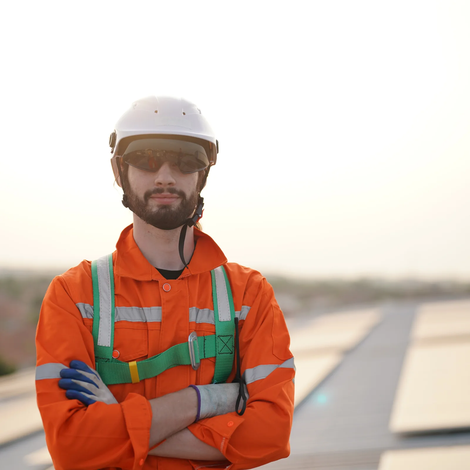 commercial-tpo-roofing-phoenix-az-contractor Commercial TPO roofing in Phoenix, Arizona — a commercial roofing contractor in a hard hat, safety glasses, and harness on a flat commercial roof.