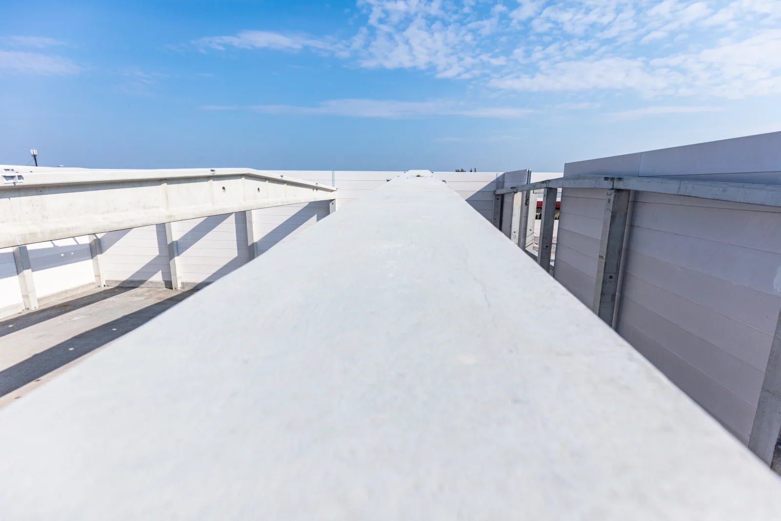 commercial-tpo-roofing-phoenix-az-reflective-membrane A wide expanse of reflective white TPO membrane on a commercial flat roof in Phoenix, Arizona, showing the seams that keep the building watertight.