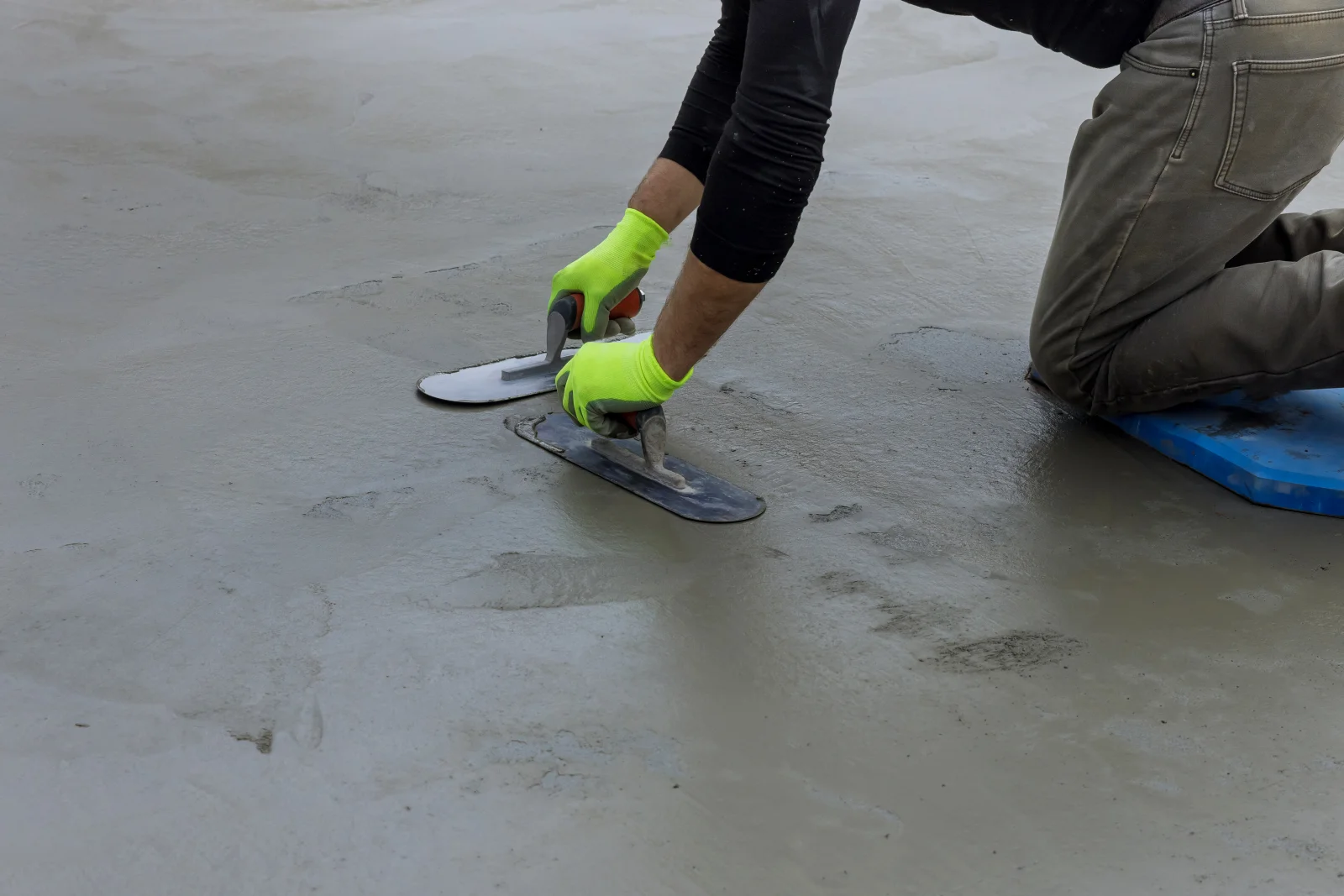 concrete-coating-phoenix-pro-troweling-finished-surface A pro in work gloves troweling and finishing a freshly prepped concrete surface in Phoenix.