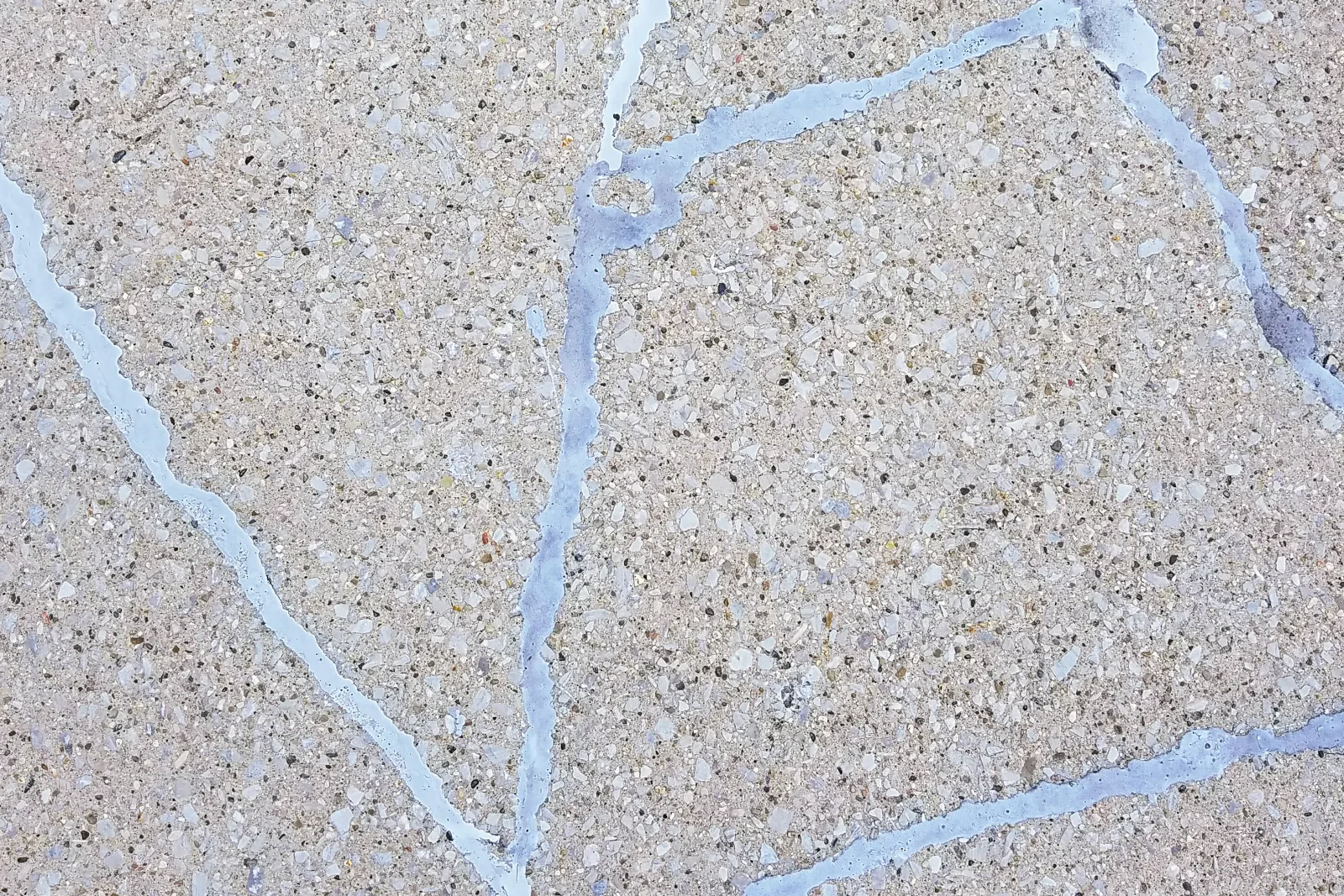 cool-deck-repair-phoenix-cracked-peeling-coating A close-up of a Phoenix cool deck crack routed out and filled with sealant, the kind of crack repair a pro does before recoating a sun-faded, chalking deck.
