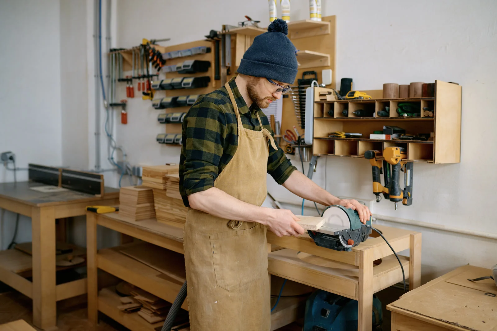 A Phoenix carpenter measuring and cutting wood shelving for a custom bookshelf build.