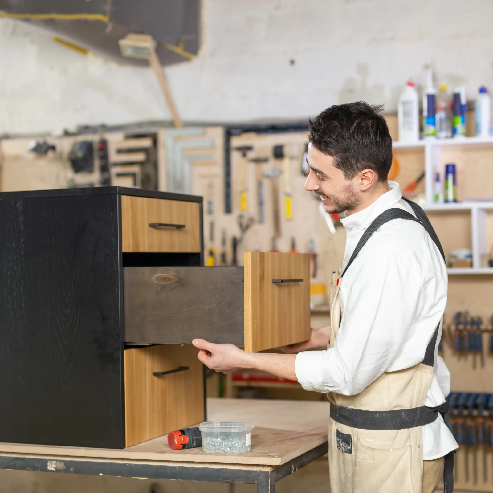 custom-cabinets-phoenix-carpenter-building Custom cabinets in Phoenix, Arizona — a carpenter in work attire building a custom cabinet in a bright Southwest-style workshop.