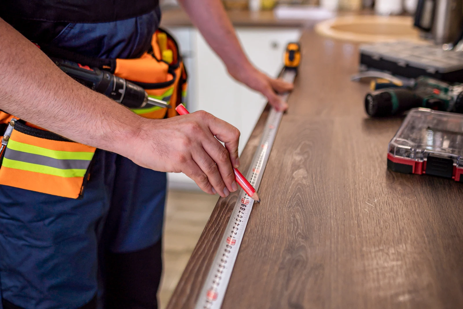 custom-cabinets-phoenix-measuring-design A carpenter measuring a Phoenix, Arizona kitchen for custom cabinets during the in-home design and measuring consultation.