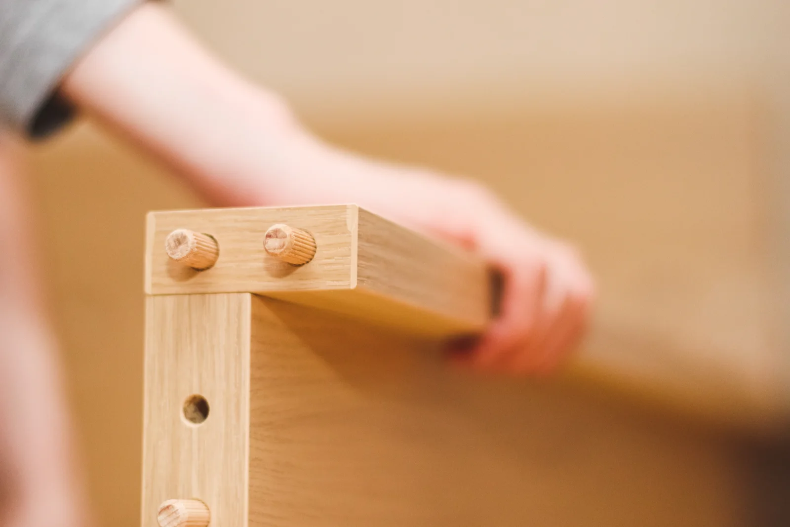 custom-furniture-phoenix-workshop-joinery A furniture maker in a Phoenix, Arizona workshop assembling mortise-and-tenon wood joinery built to withstand the region's dry desert climate.