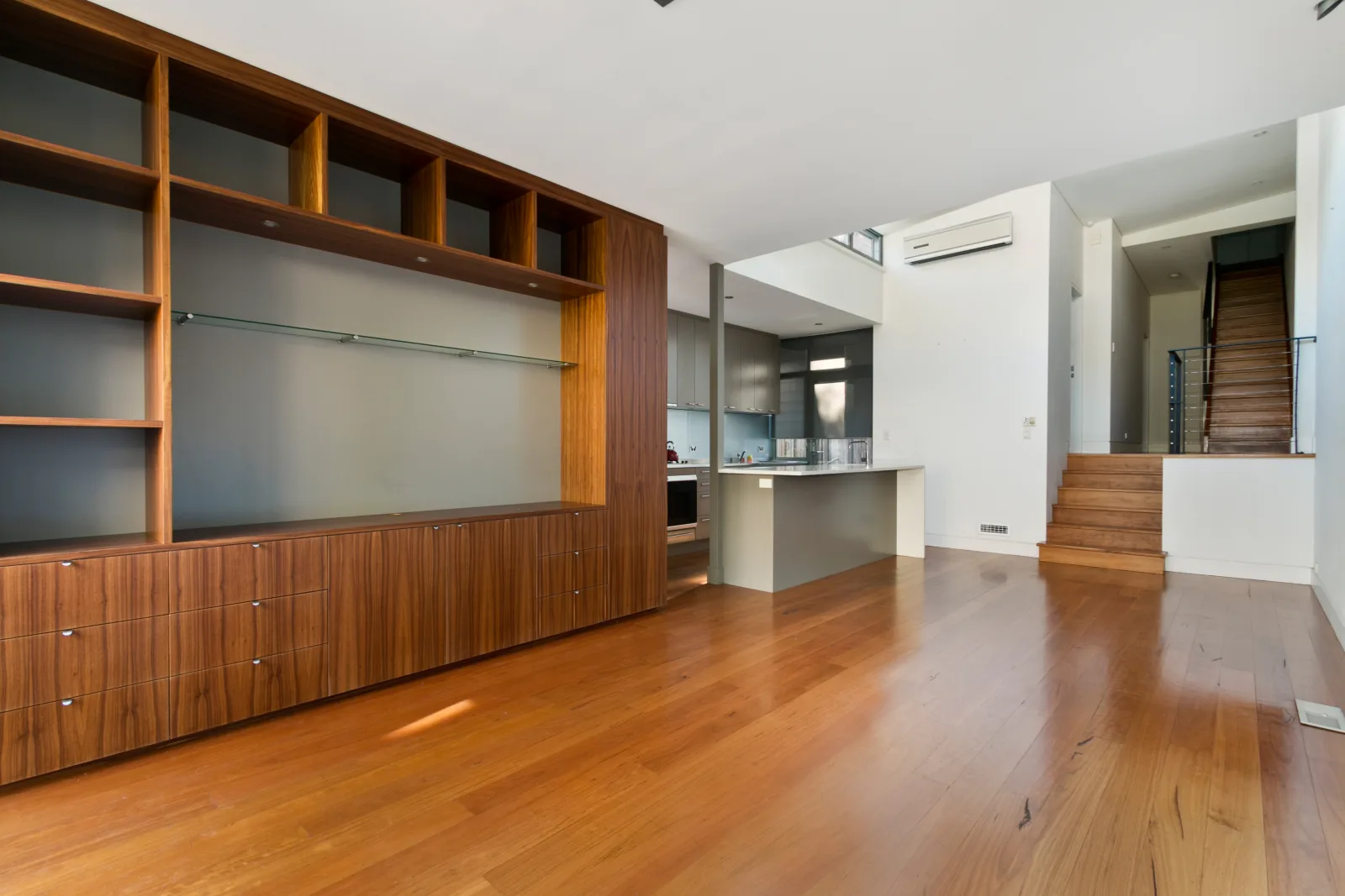 A finished custom wood built-in wall unit with open shelving in a Phoenix, Arizona home.
