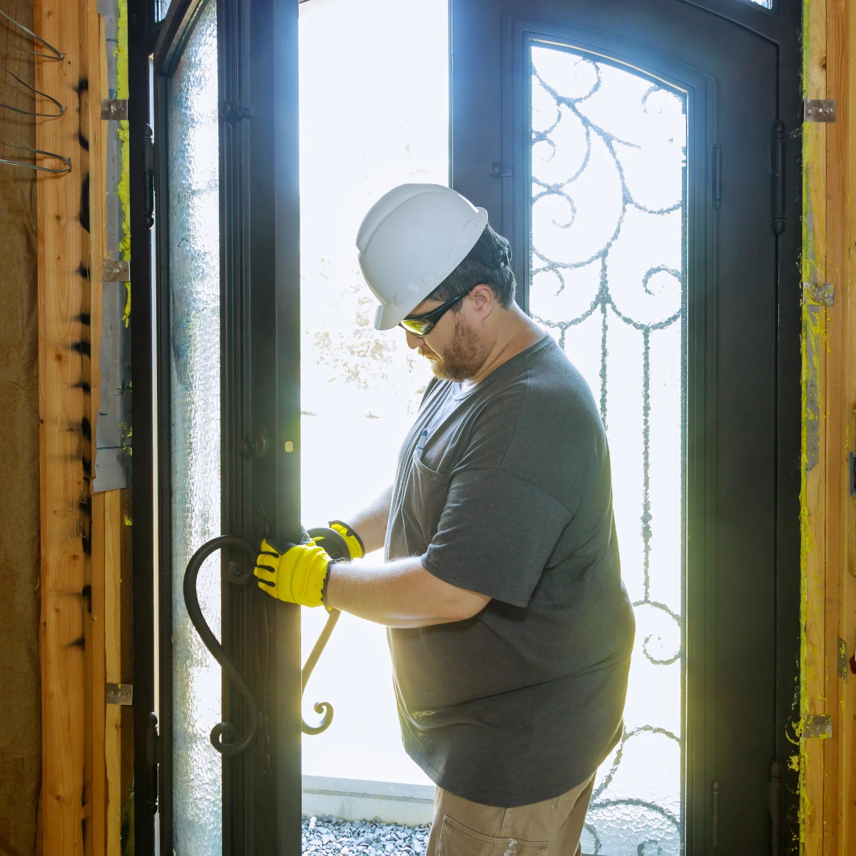 door-installation-phoenix-entry-door Door installation in Phoenix, Arizona — a carpenter installing a new energy-efficient front entry door on a desert home.