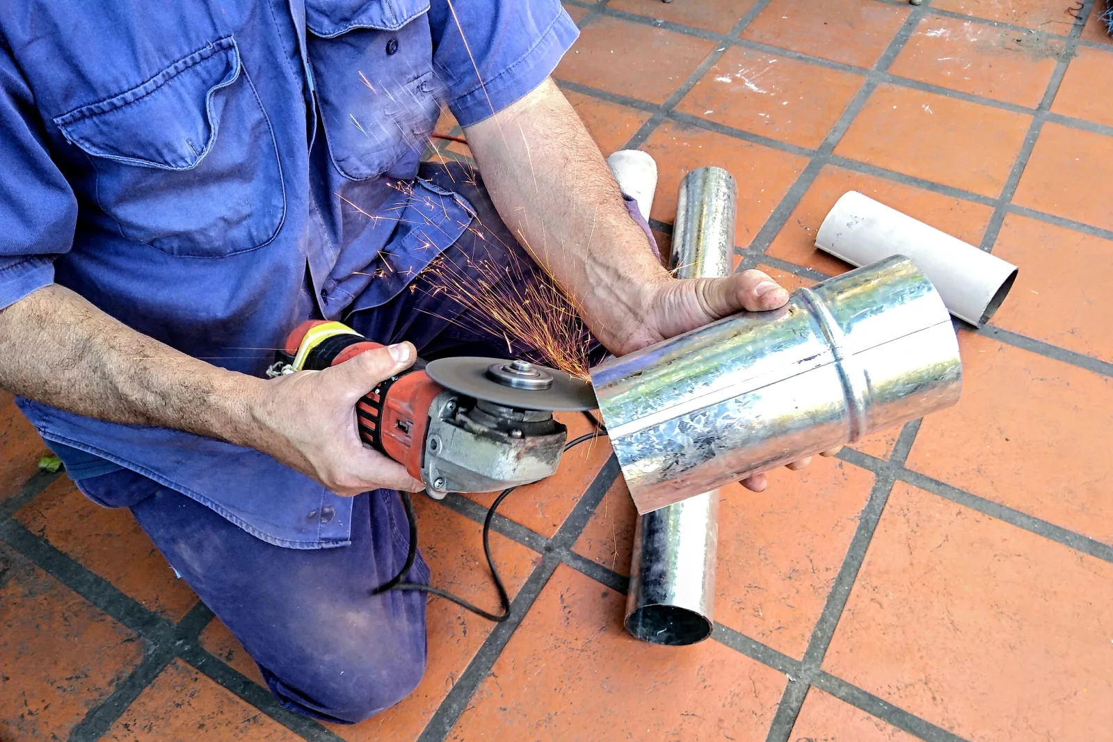 A pro custom-cutting a rigid metal vent pipe section to fit a Phoenix home's dryer vent installation.