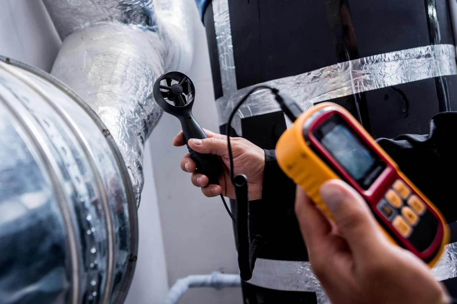 duct-sealing-phoenix-leak-test An HVAC technician running a duct leakage test on a Phoenix home's air handler to measure how much cooled air is escaping before sealing begins.