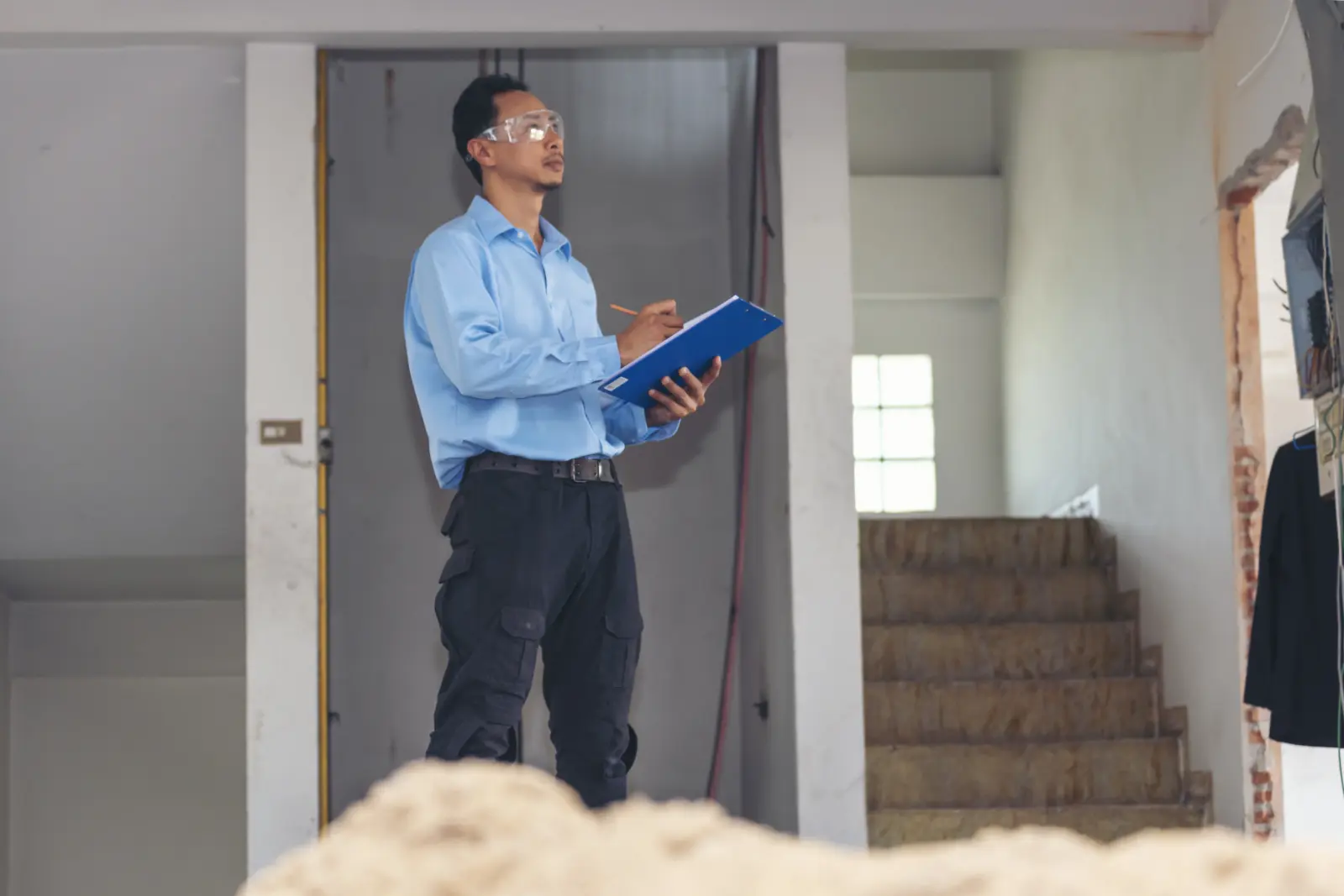 A pest control inspector reviewing a checklist while inspecting a Phoenix home's interior for pest entry points.