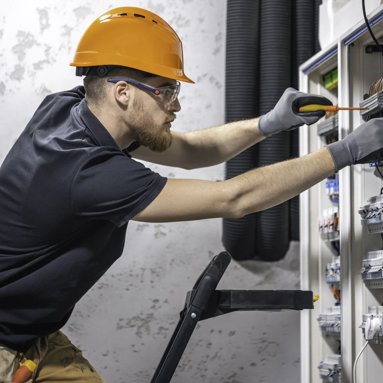 electrical-panel-replacement-phoenix-panel-install Electrical panel replacement in Phoenix, Arizona — a uniformed electrician installing a new breaker panel with proper safety gear.