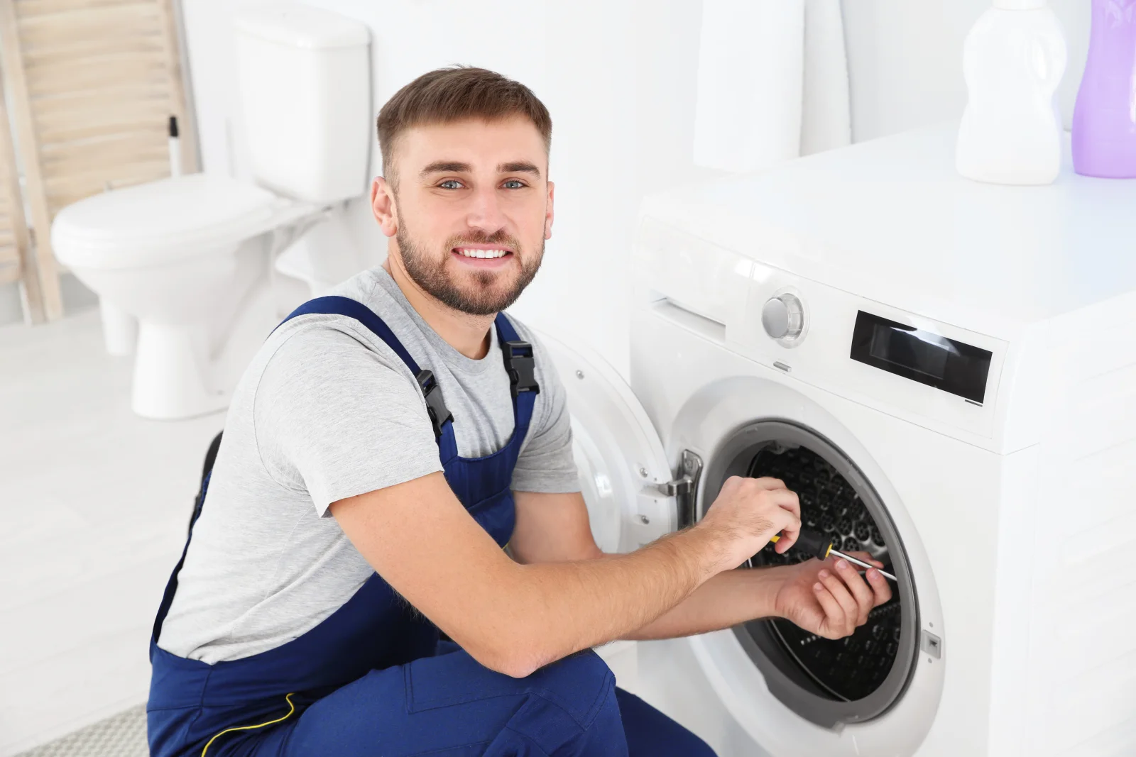 A Phoenix appliance technician repairing the drum on an Electrolux front-load washer showing an E21 error.