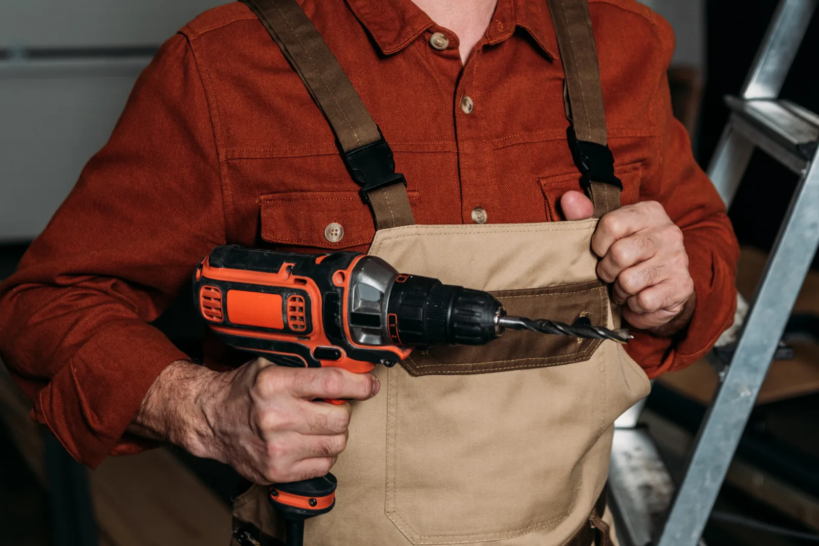 emergency-garage-door-repair-phoenix-opener-diagnosis A technician using a power drill to repair a garage door opener bracket at a residential garage in Phoenix, Arizona.