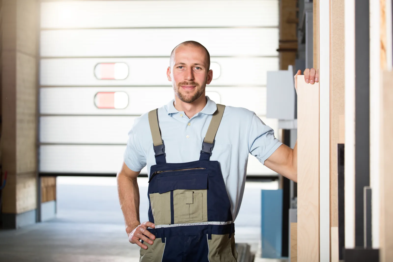 emergency-garage-door-repair-phoenix-technician-on-site A professional garage door technician standing ready at a residential garage in Phoenix, Arizona, prepared to inspect track and roller wear from summer heat.