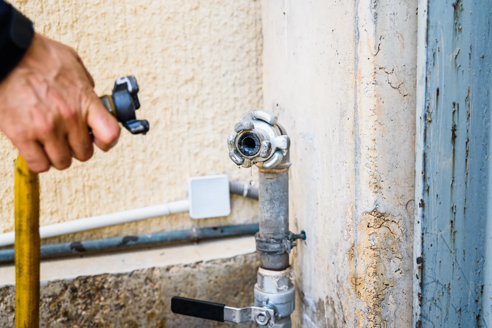 evaporative-cooler-repair-phoenix-leak-inspection An HVAC technician inspecting the water line and float valve on a Phoenix evaporative cooler to find the source of a leak.