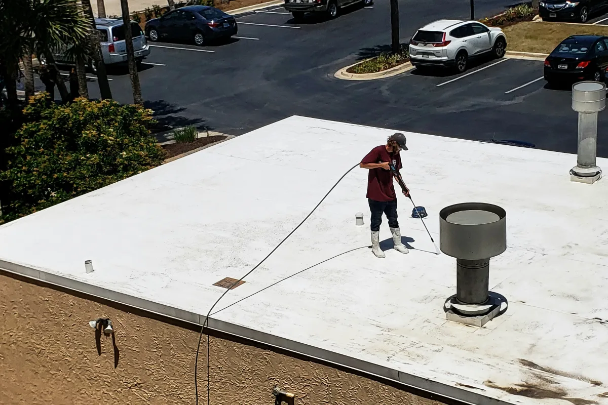 foam-roofing-phoenix-contractor Foam roofing in Phoenix, Arizona — a roofing contractor treating a white foam roof coating on a commercial building.