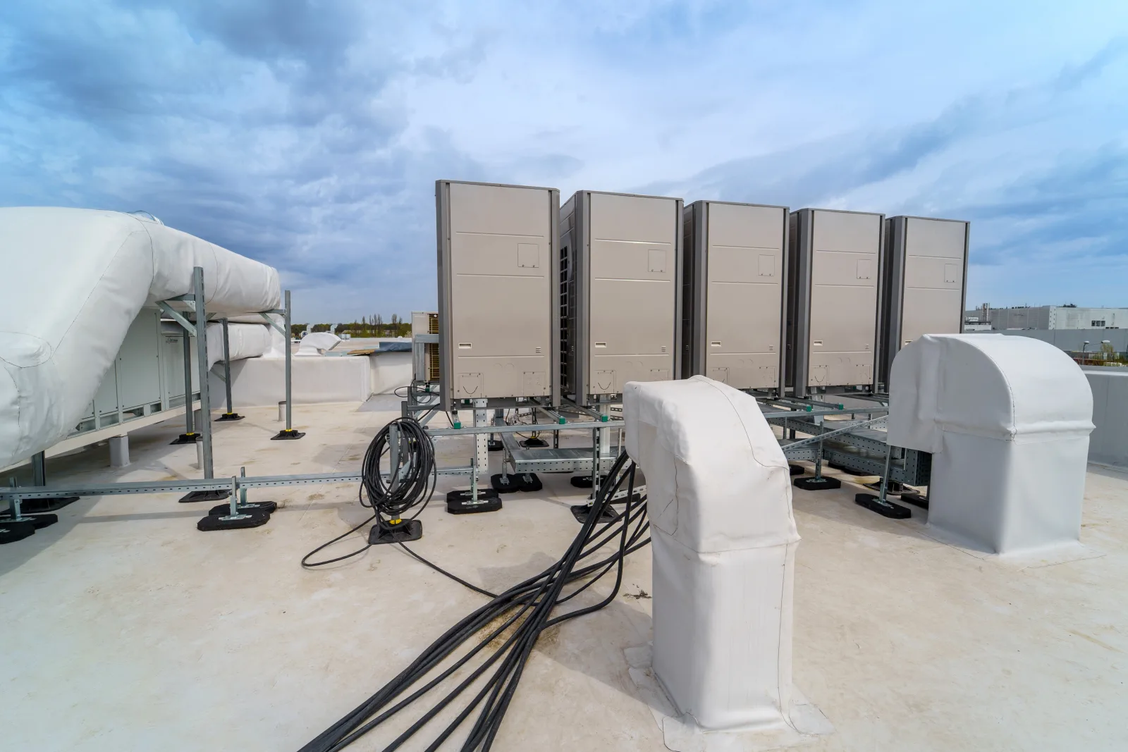 foam-roofing-phoenix-reflective-coating A reflective white foam roof coating on a commercial building in Phoenix, Arizona, with rooftop HVAC equipment mounted on the finished surface.
