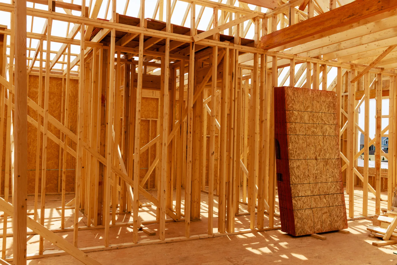 framing-contractors-phoenix-az-wall-and-roof-frame Wood wall and roof framing on a Phoenix, Arizona home addition, showing structural studs and sheathing ready for inspection.