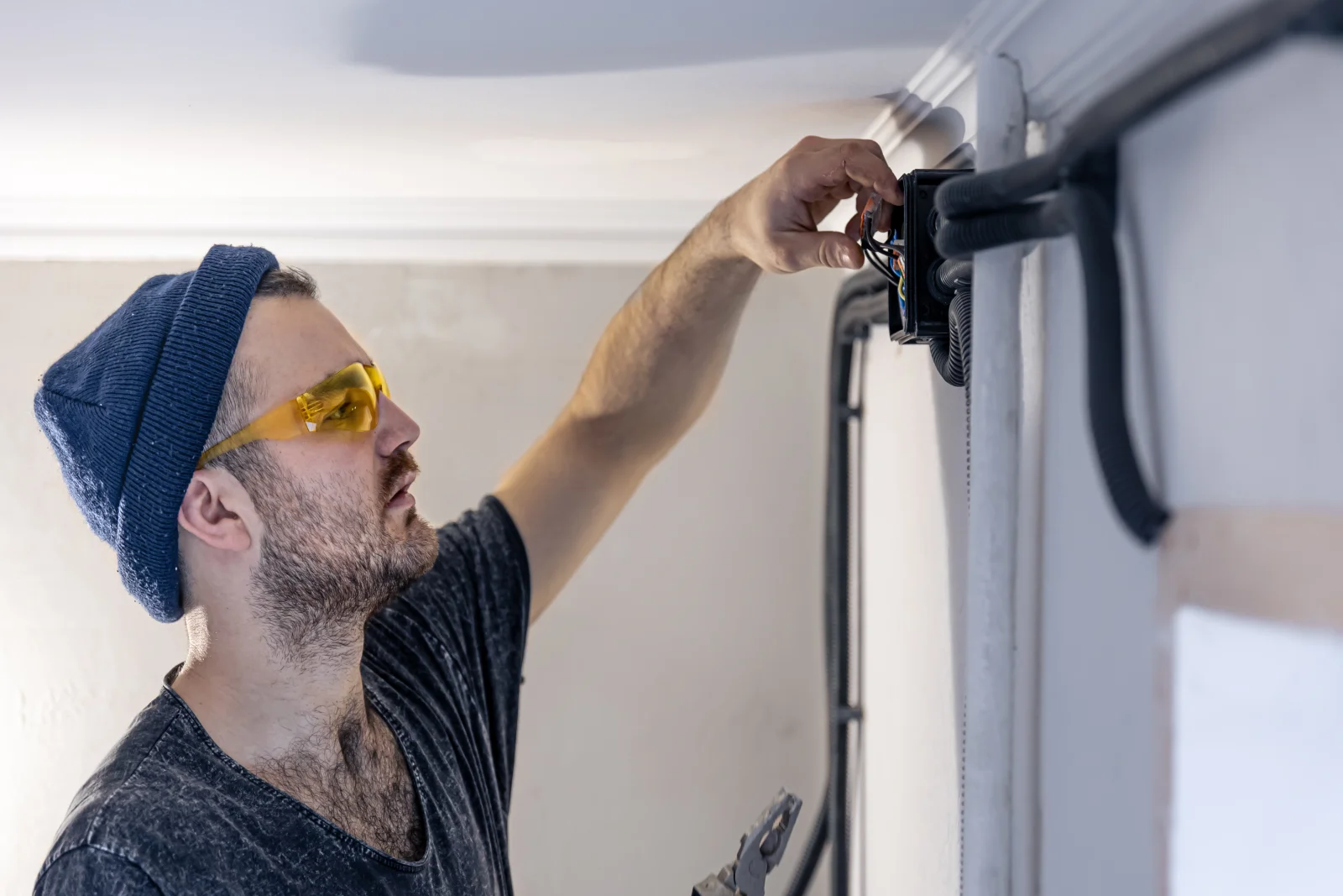 A technician wiring an electrical box for a new garage door opener during installation in Phoenix, Arizona.