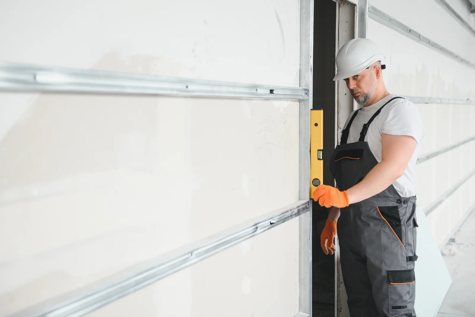 garage-door-replacement-phoenix-panel-installation A technician installing a new insulated garage door panel section on a residential home in Phoenix, Arizona.