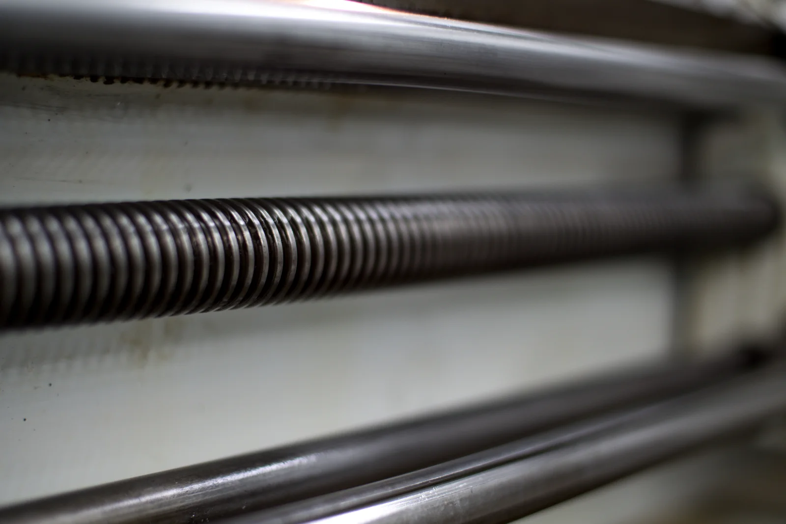 A technician inspecting a torsion spring bar mounted above a garage door in Phoenix, Arizona, checking for the wear that desert heat cycles cause over time.