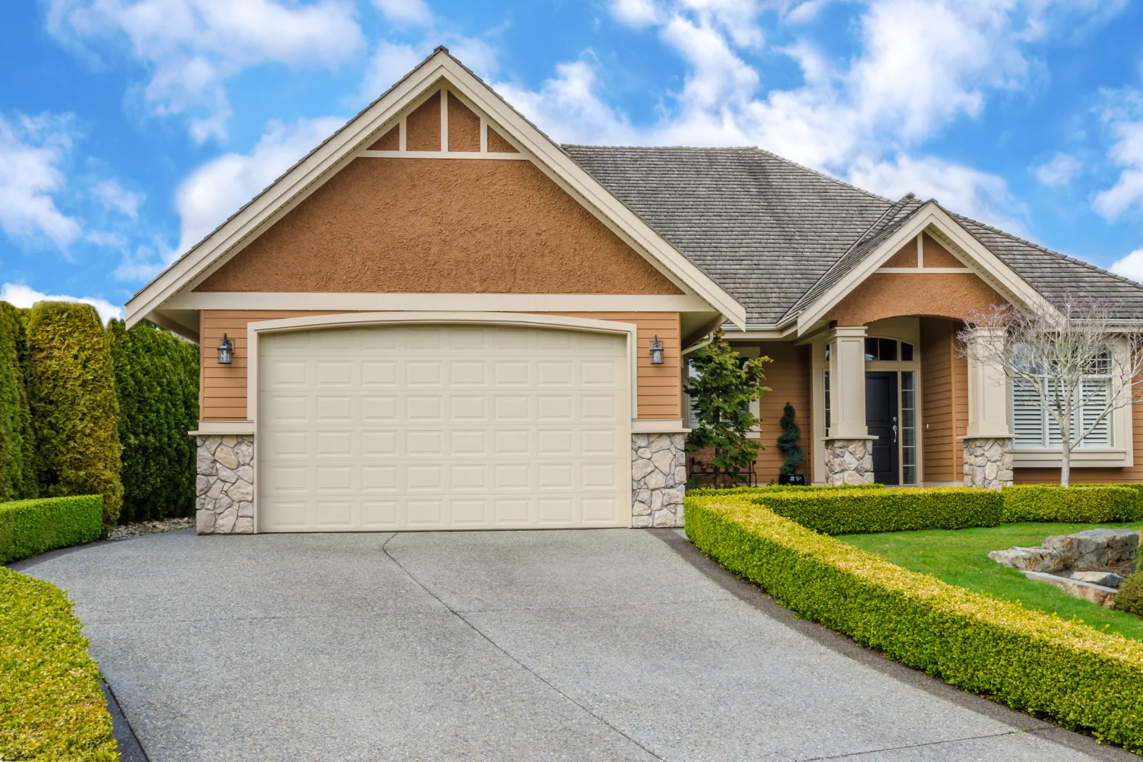 A stucco Phoenix-style home with an attached garage sitting in direct desert sun, where heat cycling wears out garage door springs and seals faster.