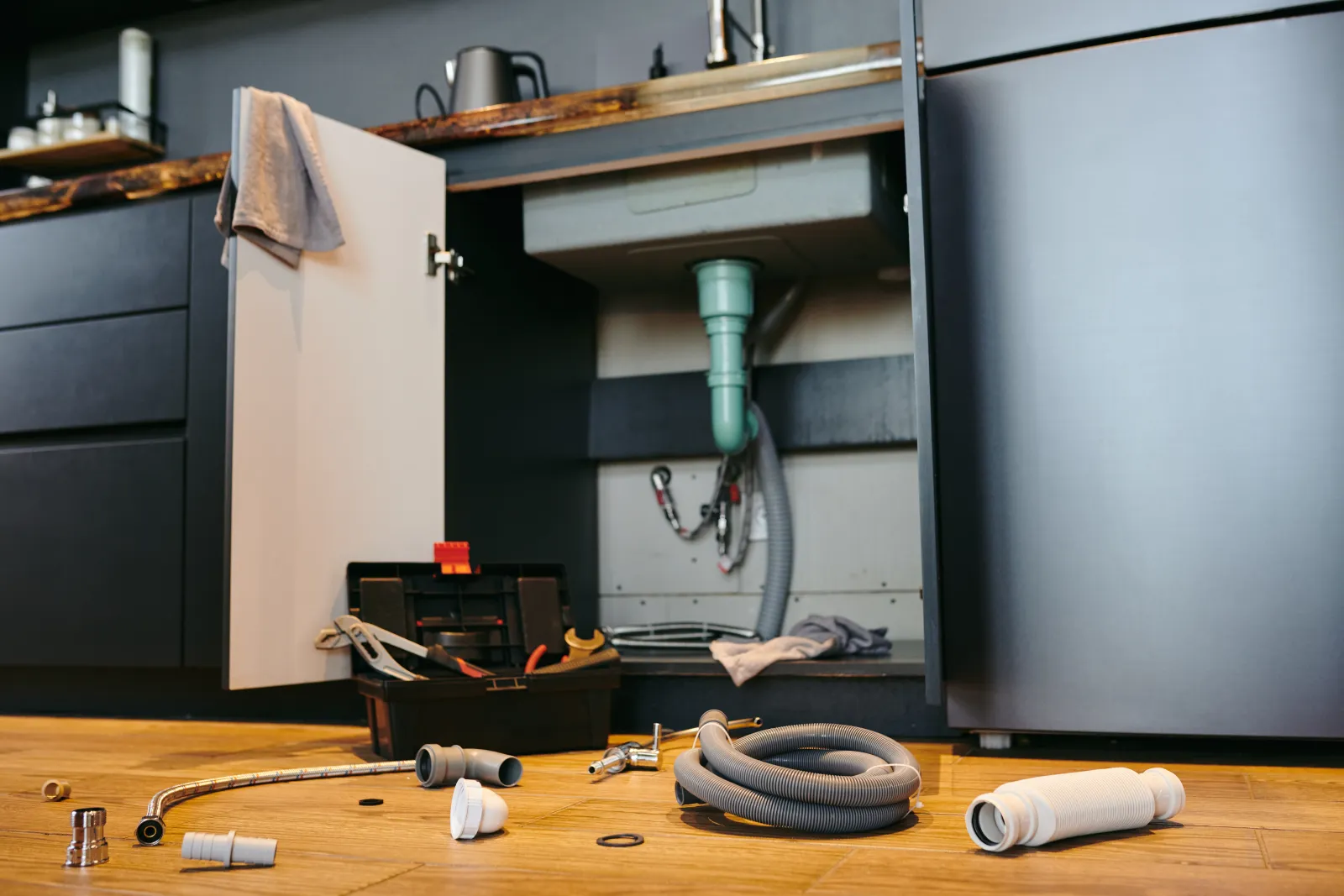 garbage-disposal-repair-phoenix-unit A garbage disposal unit mounted under the sink with its drain and dishwasher inlet connections, the kind of setup a Phoenix pro inspects to find a flange leak, hose leak, or a failed motor.