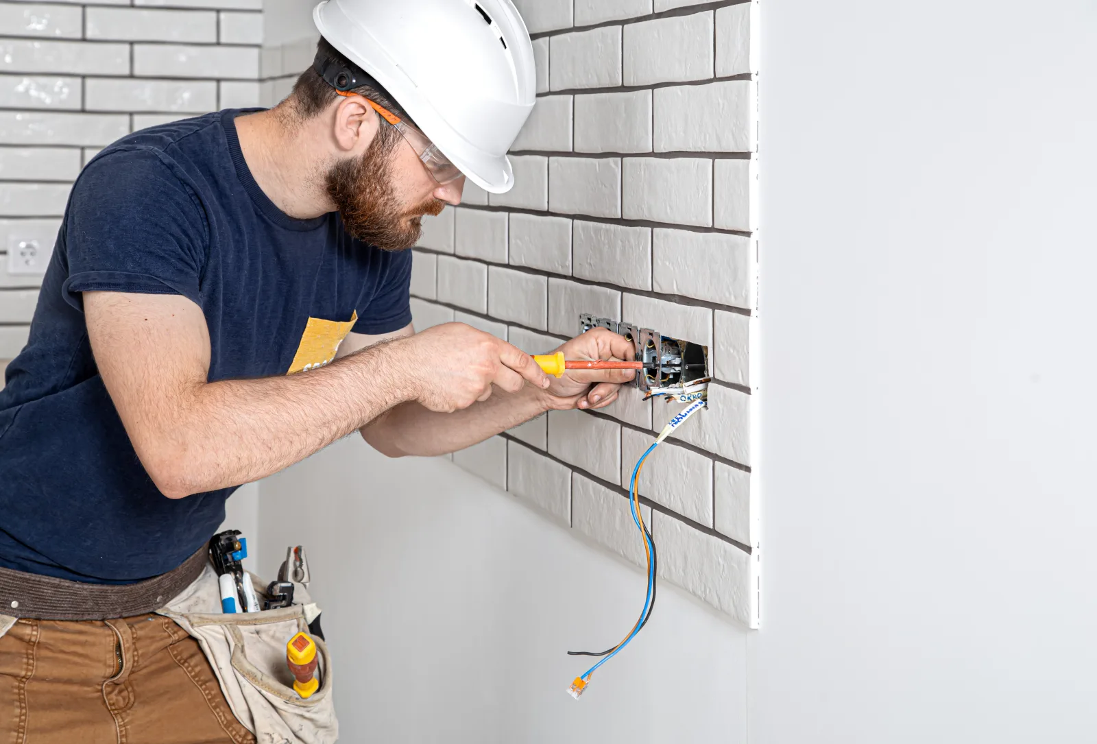 GFCI outlet installation in Phoenix, Arizona — an electrician in a hard hat wiring a new outlet box during an upgrade.