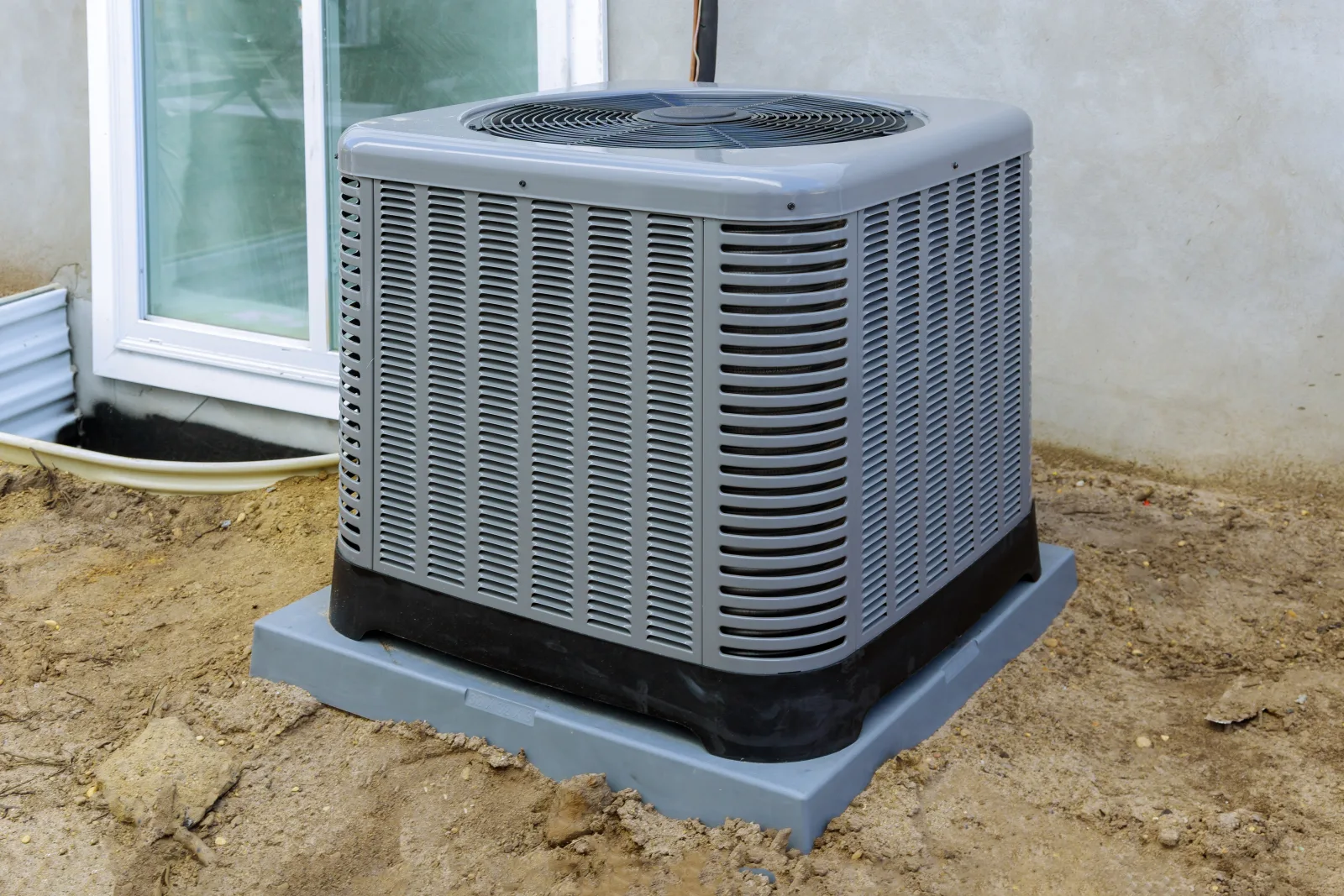 heat-pump-installation-phoenix-outdoor-condenser-unit Heat pump installation in Phoenix, Arizona — a new outdoor heat pump condenser set on a level pad beside a stucco home.