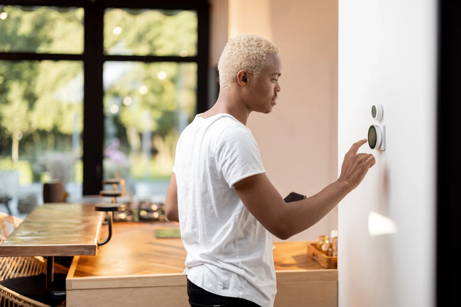 heat-pump-installation-phoenix-smart-thermostat-setup Heat pump installation in Phoenix, Arizona — a homeowner adjusting a newly installed smart thermostat that controls both heating and cooling.