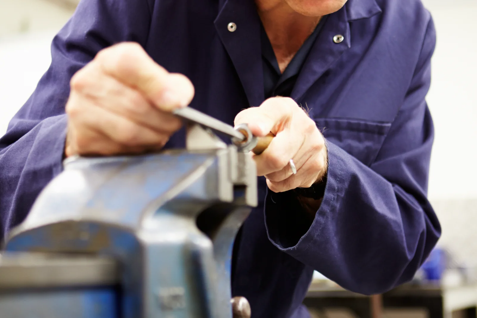 A locksmith cutting a new key blade on a portable machine to replace a lost car key fob during a Phoenix service call.