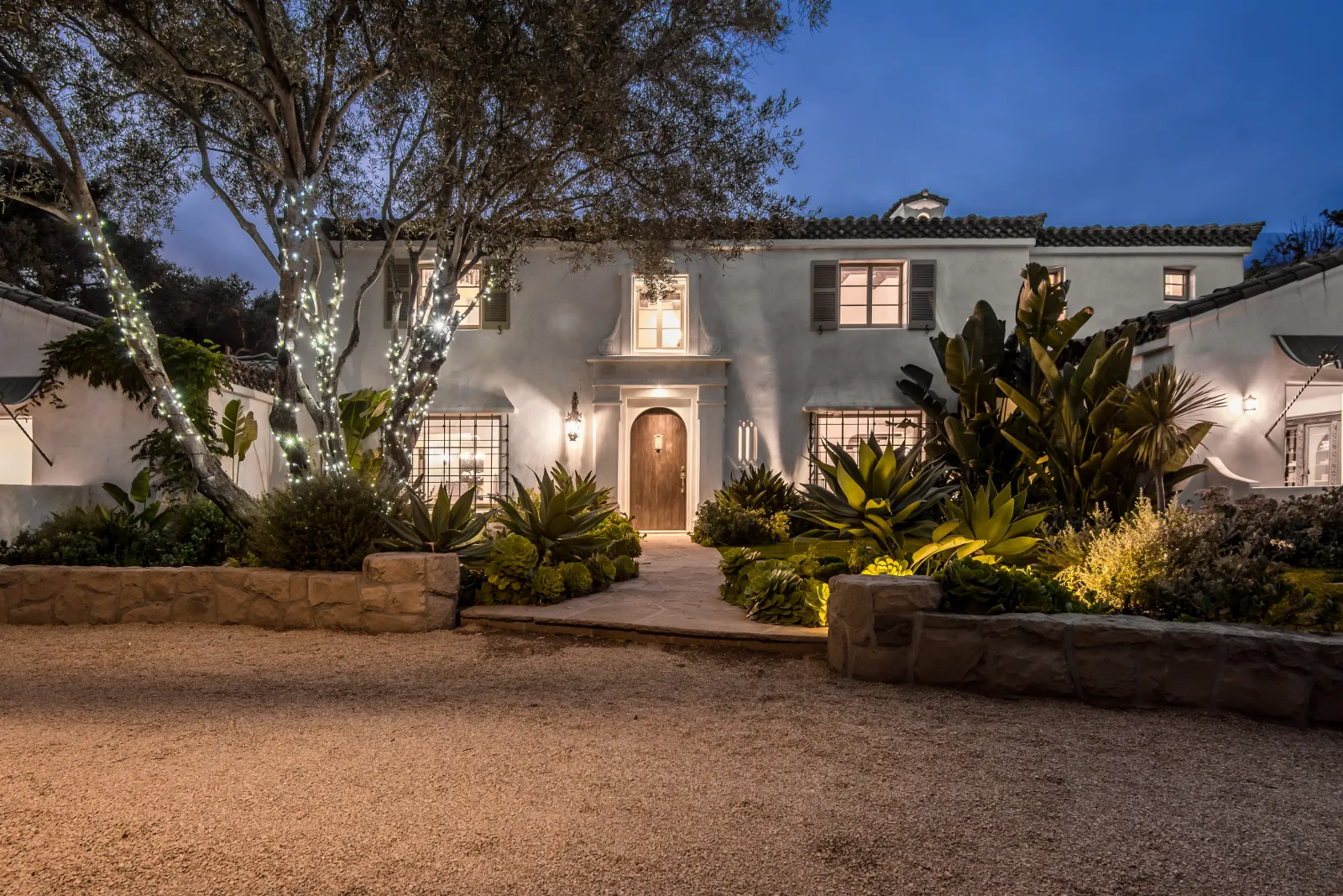 landscape-lighting-phoenix-low-voltage-led Low-voltage LED landscape lighting illuminating a Phoenix desert home at dusk, uplighting agaves and a stone walkway the way the Arizona standard install is built.