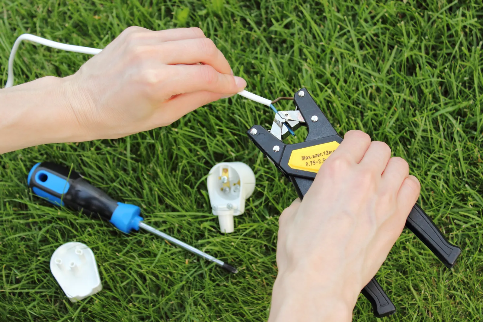 landscape-lighting-phoenix-repair-retrofit A landscape lighting pro splicing low-voltage wiring with waterproof connectors to repair and retrofit an existing Phoenix system to energy-saving LED fixtures.